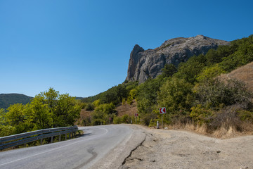 A winding asphalt road on the Black Sea coast of Crimea on a summer day.