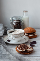 sandwich with chocolate-milk paste, bananas and nuts with coffee on a white table