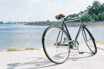 Fototapeta na wymiar bicycle near blue river in summer in sunshine