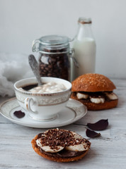sandwich with chocolate-milk paste, bananas and nuts with coffee on a white table