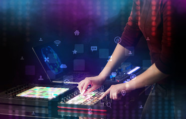 Hand mixing music on dj controller with social media concept icons