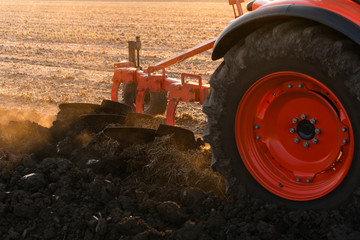 Tractor plowing fields in sunset