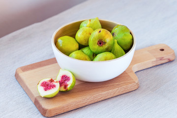Bowl with figs on a wooden board, soft focus