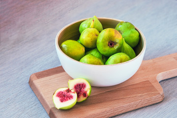Bowl with figs on a wooden board, soft focus