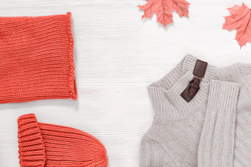 Female autumn clothing, warm knitted scarf and cap pink trend colored and light woolen beige jamper. Shopping overview concept with copy space. Top view. Flat lay.