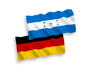 National vector fabric wave flags of Germany and Honduras isolated on white background. 1 to 2 proportion.