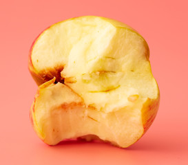 Bitten apple on a pink background