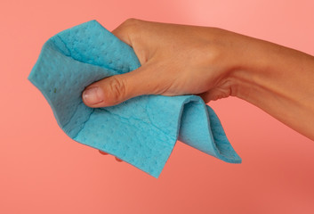 Blue rag in hand on a pink background