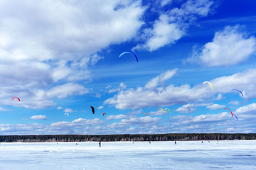 People in the sea on a kiteboard or kitesurfing.