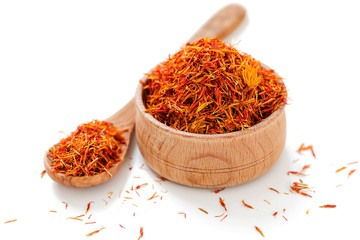 Dry Saffron in the wooden plate, isolated on white background.