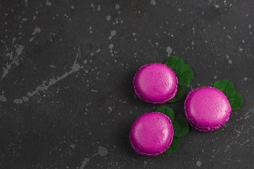 Colorful french macarons cookies(macaroons) on a dark background with copy space.