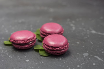 Colorful french macarons cookies (macaroons) on a dark background with copy space. Dessert for served with tea or coffee break.