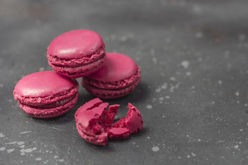 Colorful french macarons cookies (macaroons) on a dark background. Dessert for served with tea or coffee break. Holiday gift for women.
