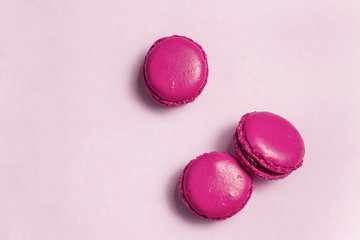Colorful pink french macarons cookies(macaroons) on a light background with copy space for postcard, banner, cover. Dessert for served with tea or coffee break.