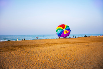 Colourful parachute gliding in the beach of Muscat, Oman