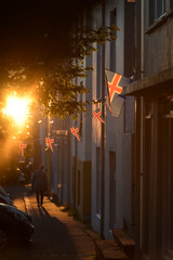 Isländische Nationalfahne an einem Wohnhaus in Reykjavik leutet im Glaz der tiefstehenden Mitternachtssonne