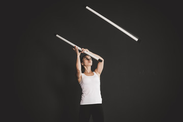 Obraz na płótnie Canvas Strong jongler girl training, black background 