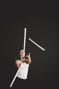 Strong jongler girl training, black background  