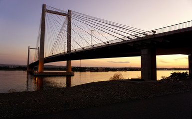 Fototapeta na wymiar Cable-stayed bridge over river at sunset
