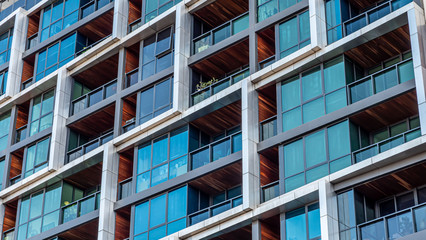 Modern multi-dwelling buildings, balconies close up. Family apartments in a strata living scheme of common property. - obrazy, fototapety, plakaty