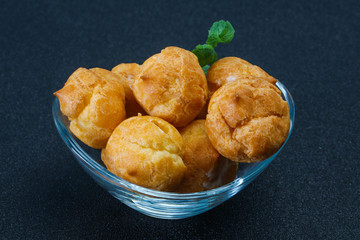 Sweet tasty profiteroles heap in the bowl