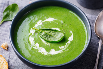 Spinach soup with cream in a bowl. Close up.