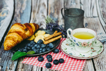 Petit déjeuner avec thé myrtilles biscuits et croissant