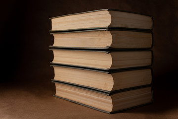 Old books on a brown background in the dark