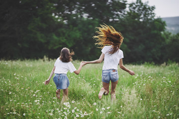 Fototapeta premium mother and daughter running in the field
