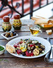Grilled vegetables salad with feta cheese in white plate on wooden background. Copy space.