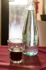 A beautifully backlit glass of red soft drink on a restaurant table