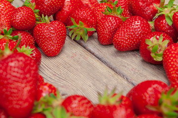 Red ripe strawberries on wooden table close up