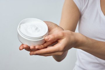 young woman applying moisturizer cream
