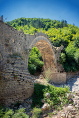 Fototapeta na wymiar Old Kalogeriko triple arched stone bridge on Vikos canyon, Zagorohoria, Greece