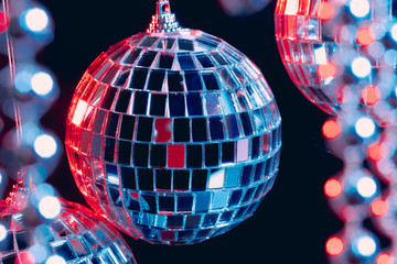 Sparkling disco balls hanging in the air against black background