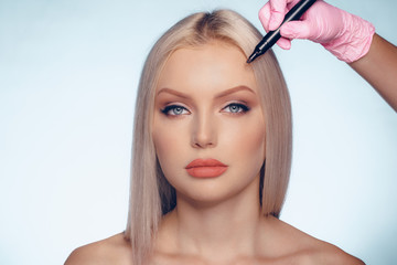 Naklejka premium Woman face and doctor hands with pencil. Plastic surgery concept