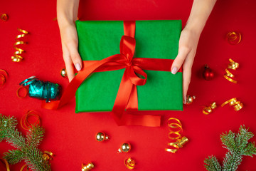 Female hands holding present on a red background