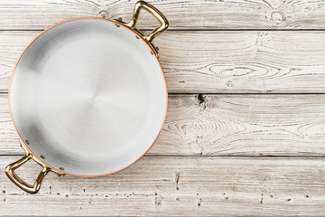 Flatlay of copper cooking pot on wooden background