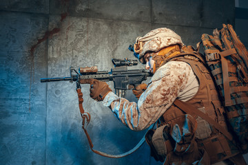 American private military contractor shooting a rifle. Studio shot