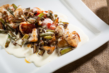 Tasty meat dish with vegetables and white sauce, food close-up