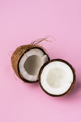 Coconut. Broken coconut on pink background.Two coconut halves. Copyspace