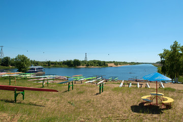A place by the lake with kayaks on a summer day.