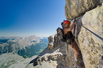 two women mountain climbers on an exposed Via Ferrata in the Dolomites of Italy