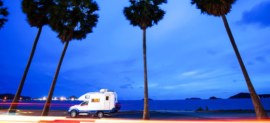 Journey in motorhome on palm beach road at dusk.