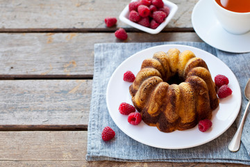 Chocolate marble bundt cake with a cup of tea on wooden background. Copy space.