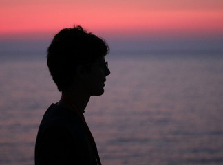 black profilo of young boy at sunset