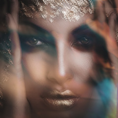 closeup of young black woman face with golden lips and makeup  intentionally blurred