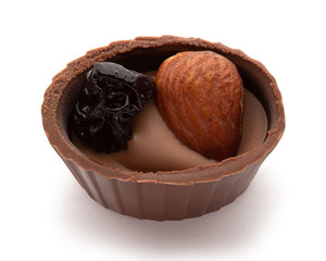 Small chocolate basket with cream, prune and nut on a white background