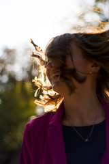 A girl in trendy plum and bright suit walks around the city and has fun. Style.