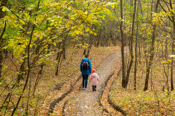 Obraz premium Mother and daughter are walking in the autumn forest